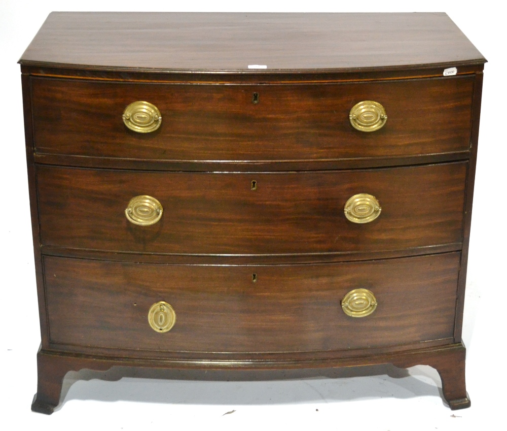 A George III Mahogany Bowfront Chest, circa 1800, the three deep graduated drawers with brass oval