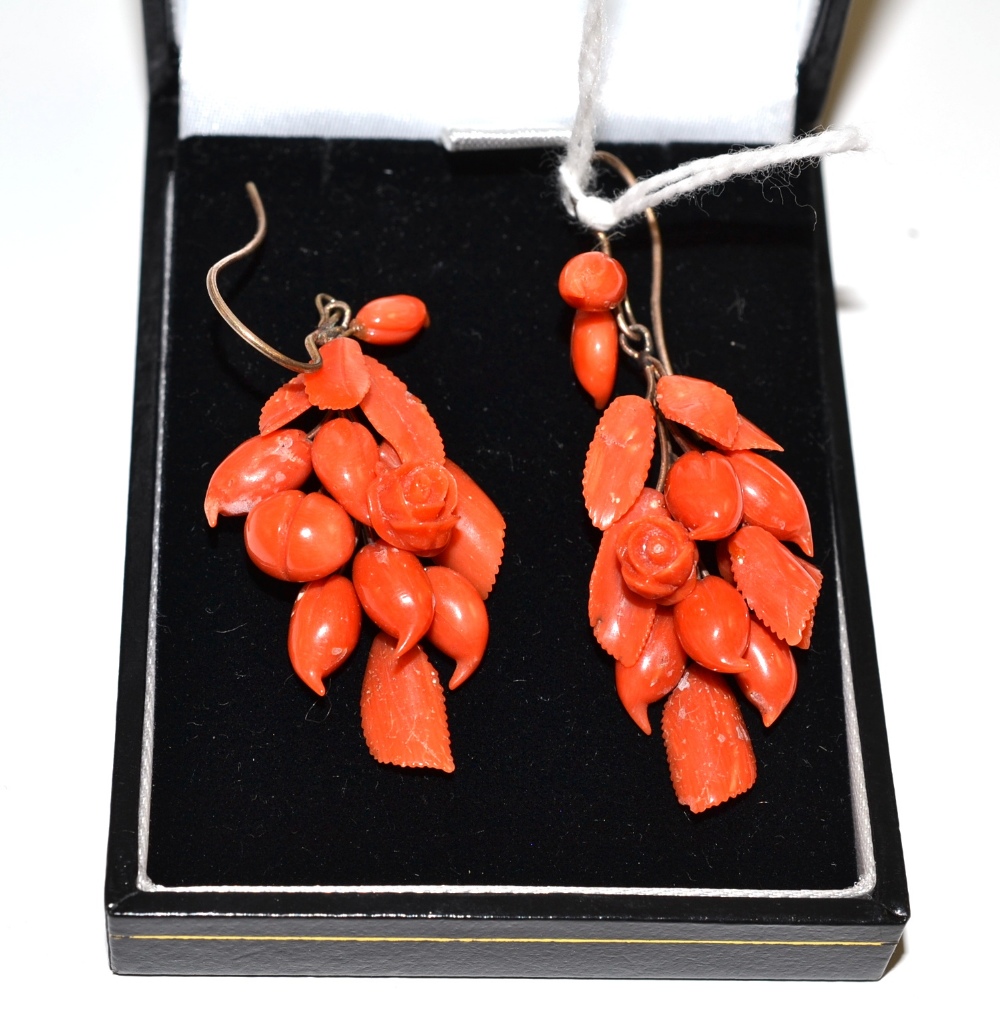 A pair of coral drop earrings, depicting roses, buds and leaves, with hook fittings for pierced
