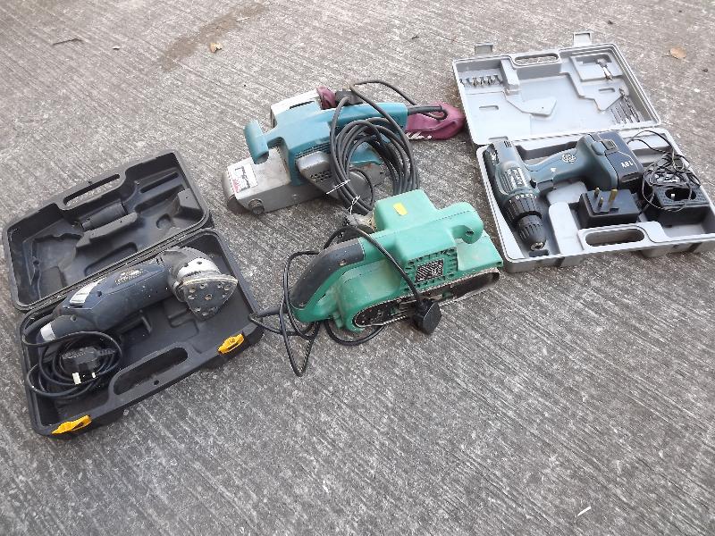 Four cased portable power tools to include a drill and three sanders