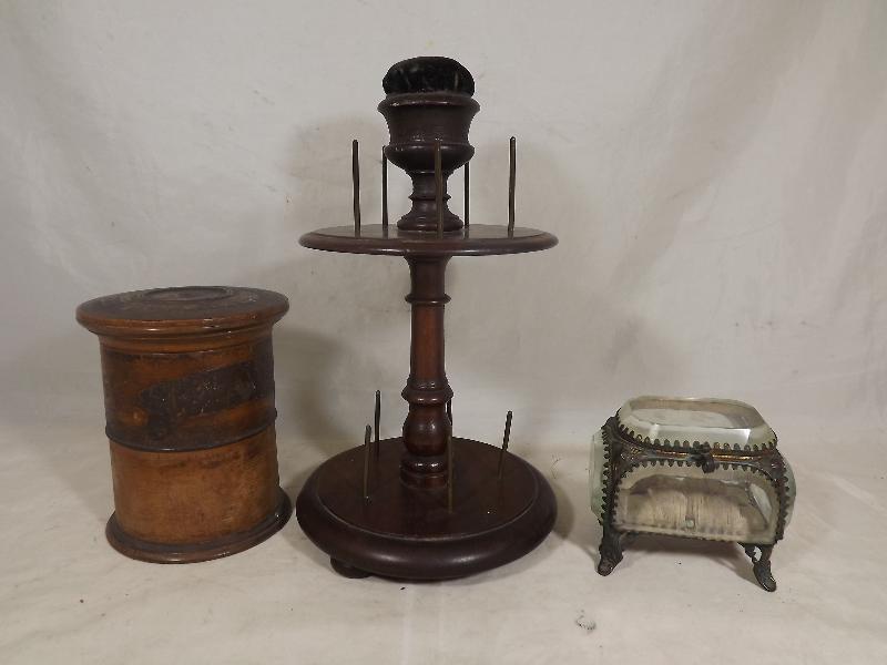 A mahogany cotton reel stand with pin cushion, a faceted glass pin cushion box, and a wooden