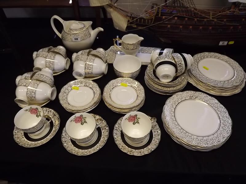 A collection of ceramic tableware to include a tea pot, cups, saucers, creamer, sugar bowl, cake