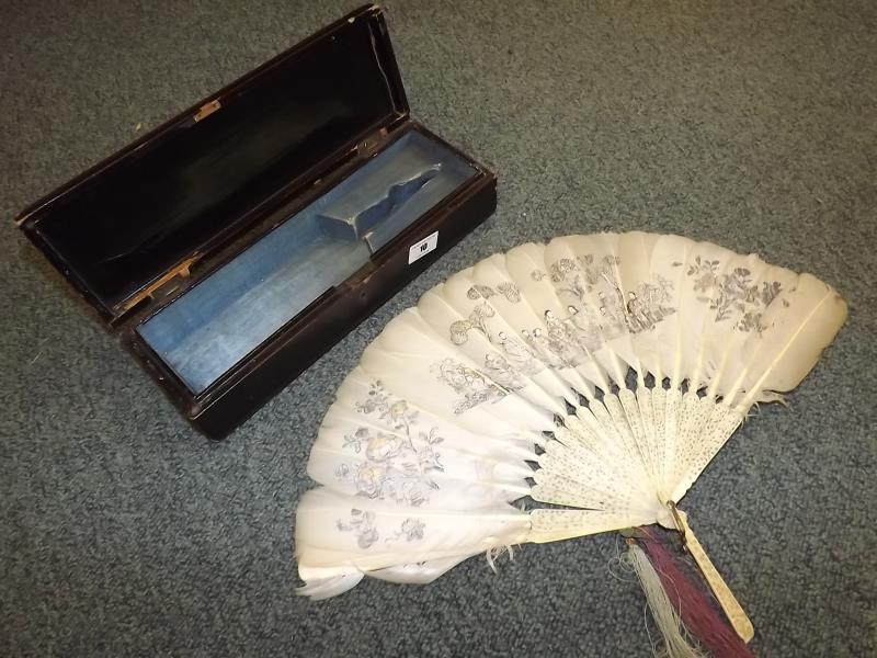 An early 20th century Japanese feather fan with bone with pierced decoration in a fitted papier