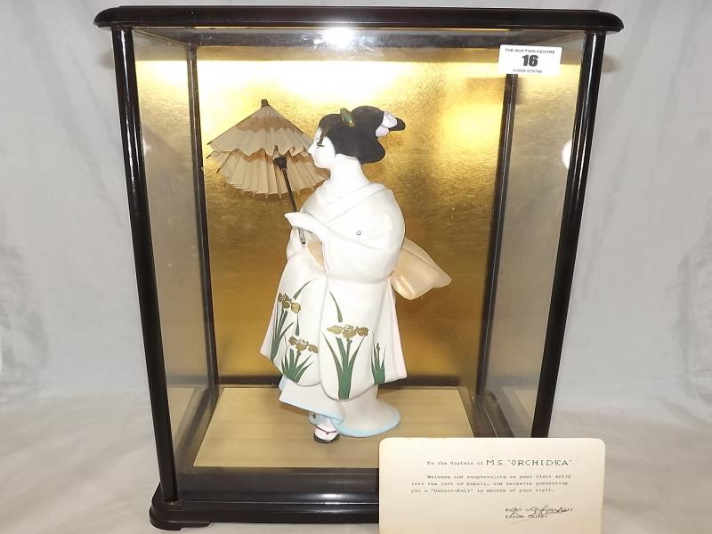 A hand painted Hakata doll in glass presentation case, given as a gift from the Mayor of Fukuoka