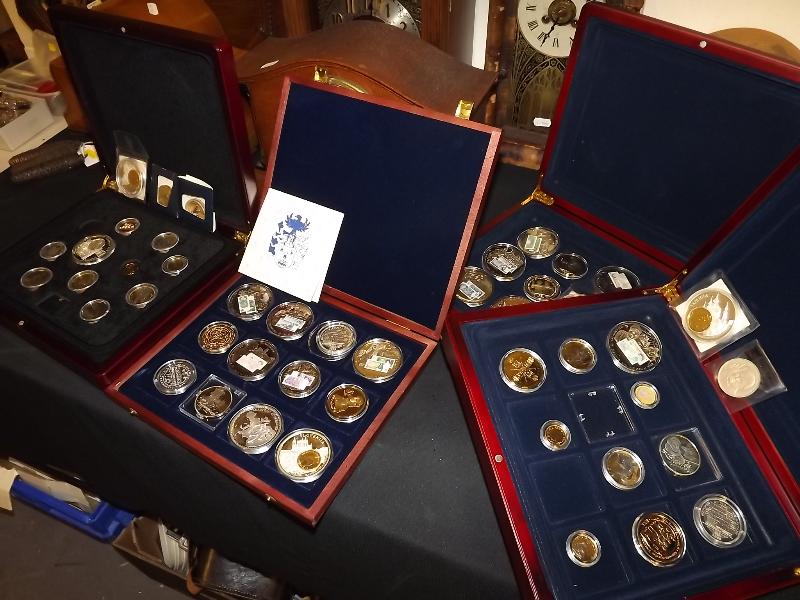Four presentation cases containing a collection of commemorative mint coins and medallions