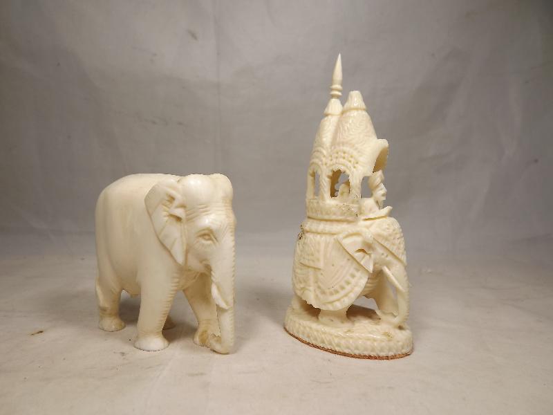 A carved ivory figurine depicting an elephant and one further carved figurine (2)