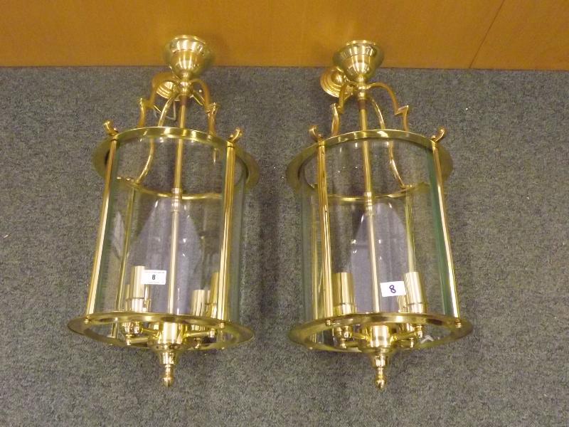 Two brass chandeliers each with four curved glass panels, 55 cms (l)