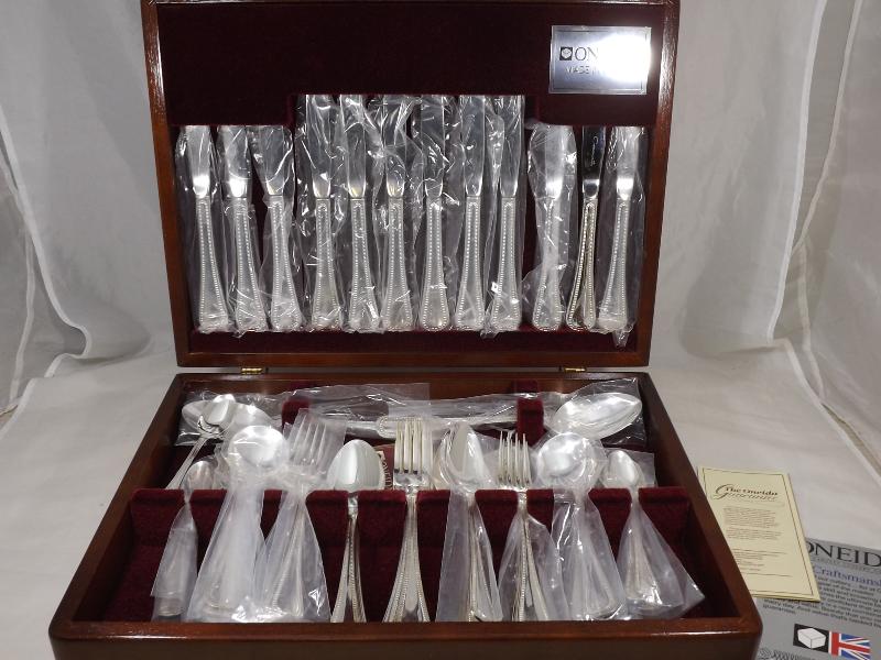 An unused mahogany cased Oneida canteen of cutlery