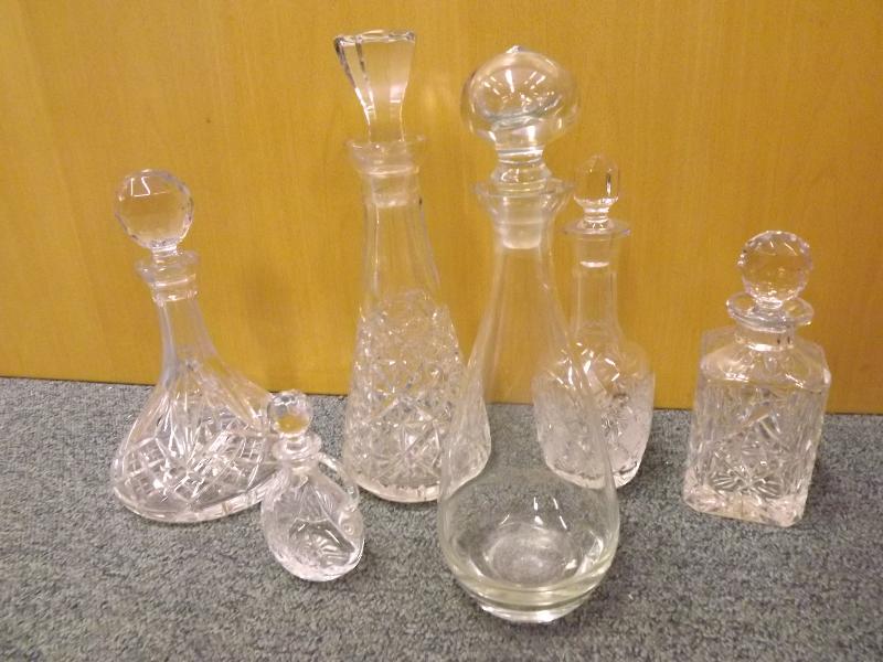 Four stoppered cut glass decanters and one further decanter and a stoppered perfume jug