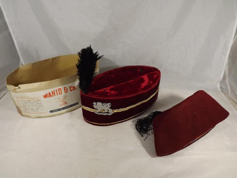 A regimental hat, Singapore Guard Regiment and a fez - (2)