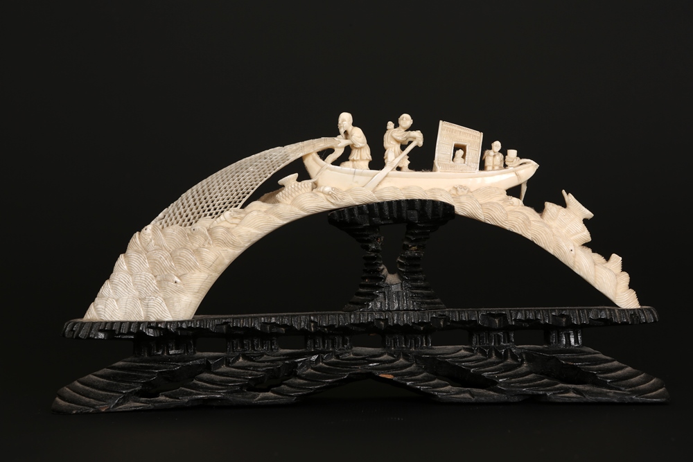 A Chinese carved ivory tusk, late 19th/early 20th Century, carved with fishermen and children on a