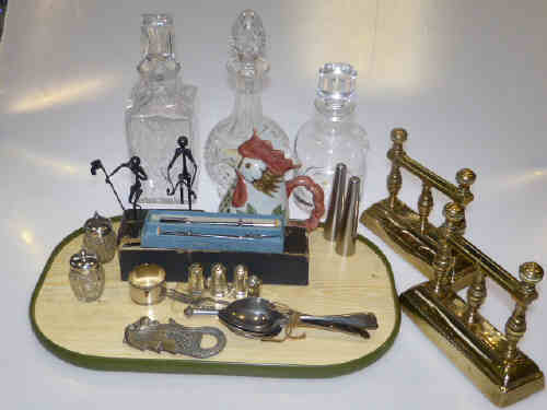 Pair of brass fire dogs, three glass decanters, pair of silver topped bottles and collectables