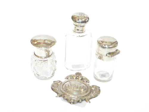 Three silver topped glass smelling salts bottles, and embossed label (4)