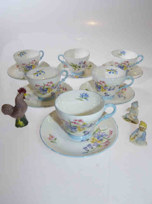 Six Shelley 'Wild Flowers' cups and saucers, two Wade figures and a pottery cockerel