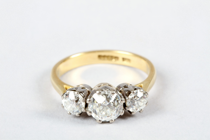 Three stone diamond ring, centre diamond 0.93 carats, colour J, clarity VS2, flanked by two 0.32