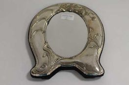 A silver horseshoe shaped photograph frame., width 22 cm.   CONDITION REPORT:  Good condition,