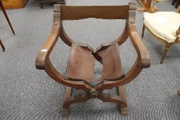 An early twentieth century carved oak X-framed armchair, width 72 cm.