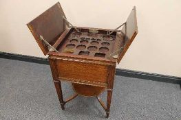 An early twentieth century oak 'Eclipse' drinks table with mechanical rise and fall action, width 54
