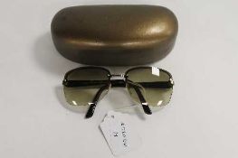 A pair of Gucci sunglasses, in golden case.   CONDITION REPORT:  Good condition but used.