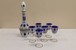A blue overlay glass decanter, with floral decoration, together with the matching set of six