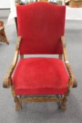 A Continental carved oak armchair, upholstered in red fabric, width 67 cm.