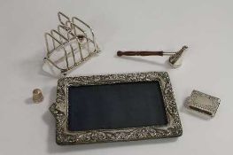 A silver toast rack, Birmingham 1947, together with a silver photograph frame, a silver vesta