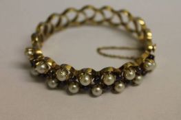 A 14ct gold sapphire and pearl bracelet, 32.9g.   CONDITION REPORT:  Good condition. Firm hinged