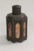 A Chinese octagonal pewter caddy, with panelled sides decorated with figures, height 18 cm.