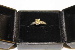 A platinum natural fancy yellow diamond ring, set with diamond shoulders, 1.03ct, with GIA