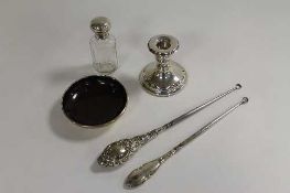 A small silver candlestick, Birmingham 1915, together with a silver topped glass bottle, a silver