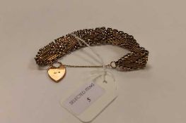 A 9ct gold flat-linked bracelet with heart clasp, 28.4g.   CONDITION REPORT:  Good condition, side
