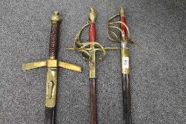 Three swords with brass hilts and leather scabbards. (3)   CONDITION REPORT:  Some damages to