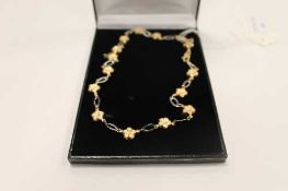 A 9ct gold floral necklace, 9.2g.   CONDITION REPORT:  Yellow metal hallmarked 9ct gold, the white