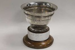 A silver trophy on turned wooden plinth, London mark, date stamp 1932.    CONDITION REPORT:  Fixed