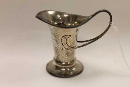 A silver Arts & Crafts style cream jug by George Unite, height 10 cm.    CONDITION REPORT:  Good