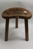 A carved oak three legged stool by Robert 'Mouseman' Thompson of Kilburn.   CONDITION REPORT: