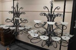 A pair of bespoke galvanised metal light fittings, each with eighteen lights and glass shades,