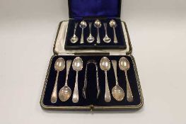 A set of six silver teaspoons with matching sugar tongs, together with another set of six silver