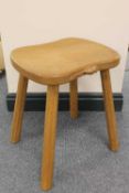 A carved oak four-legged stool by Robert 'Mouseman' Thompson of Kilburn.   CONDITION REPORT:  Good
