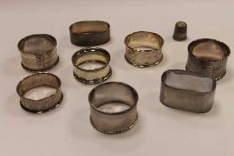 Eight silver napkin rings, together with a silver thimble.  (9)   CONDITION REPORT:  Good condition.