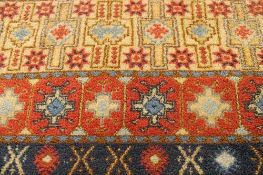 A Moroccan wool fringed carpet of geometric design on red ground, 160 cm x 270 cm.   CONDITION