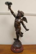 A spelter figured lamp depicting a cherub, on rouge marble socle, height 62 cm.   CONDITION REPORT:
