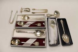 Three silver spoons with golfing terminals, together with a pair of silver sugar nips, three
