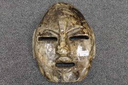 A hardstone Inuit wall mask, width 27 cm.   CONDITION REPORT:  Fair condition with some breaks and
