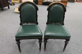 A set of four late Victorian stained mahogany office chairs with green leather upholstery. (4)