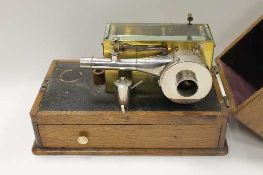 An early twentieth century brass and chromed metal mechanical instrument, fitted with a drawer and