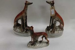 A pair of nineteenth century Staffordshire greyhound models, height 31.5 cm, together with another