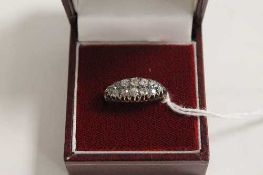 An Edwardian diamond boat-shaped ring. CONDITION REPORT: Good condition, the yellow metal shank