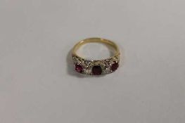 A three-stone ruby and diamond ring. CONDITION REPORT: Good condition, the shank unmarked.