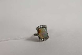 An Art Deco diamond and opal ring. CONDITION REPORT: The white metal unmarked, sadly a knock to
