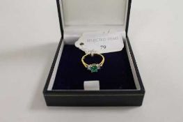 An 18ct gold three stone emerald and diamond ring. CONDITION REPORT: Good condition.